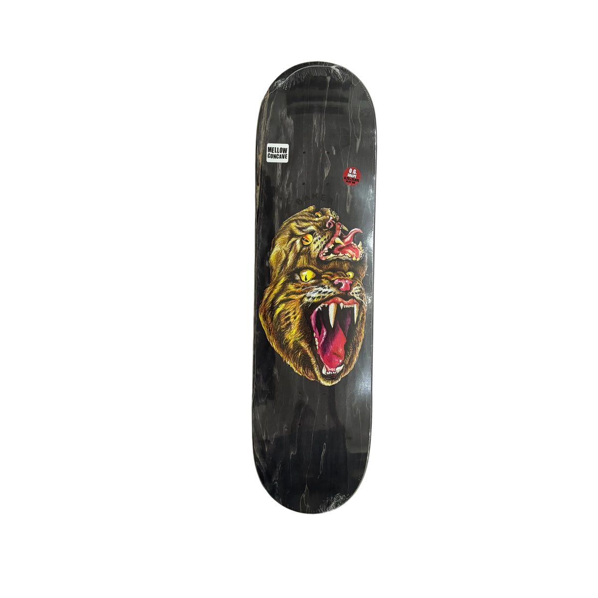 A skateboard deck with a black background and a large roaring tiger graphic in yellow, red, and white, photographed from above on a white surface.