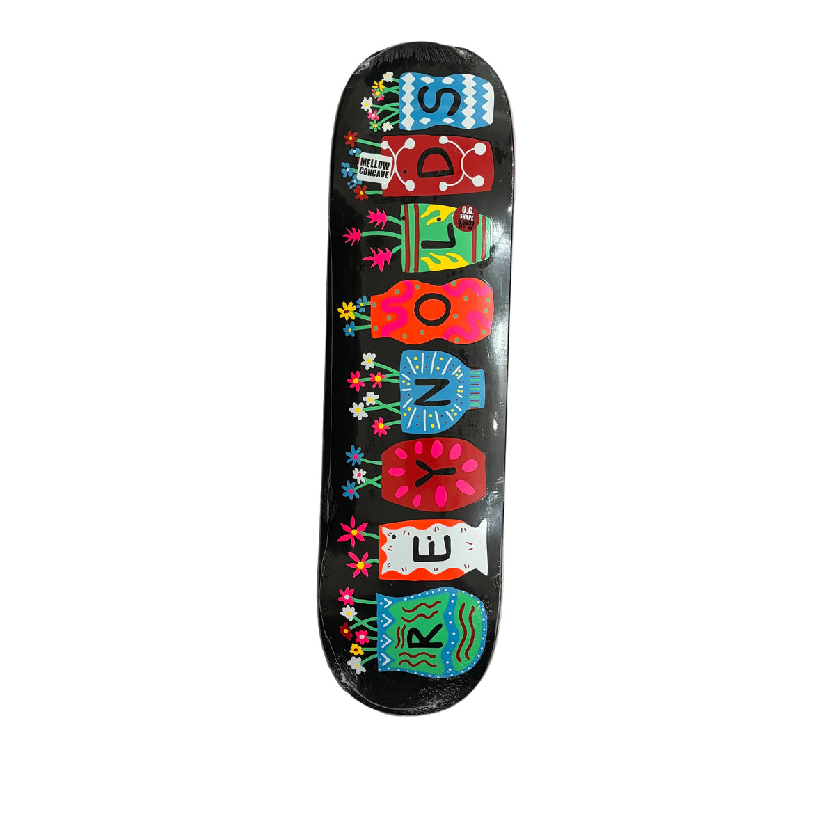 A skateboard deck with a black background and colorful folk-art style flower pots and lettering spelling 'REYNOLDS', photographed from above on a white surface.