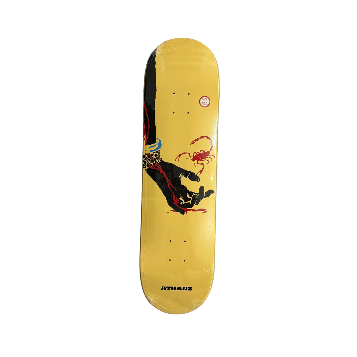 A yellow Athans skateboard deck with a graphic of a hand holding a red crab, displayed flat on a white surface.
