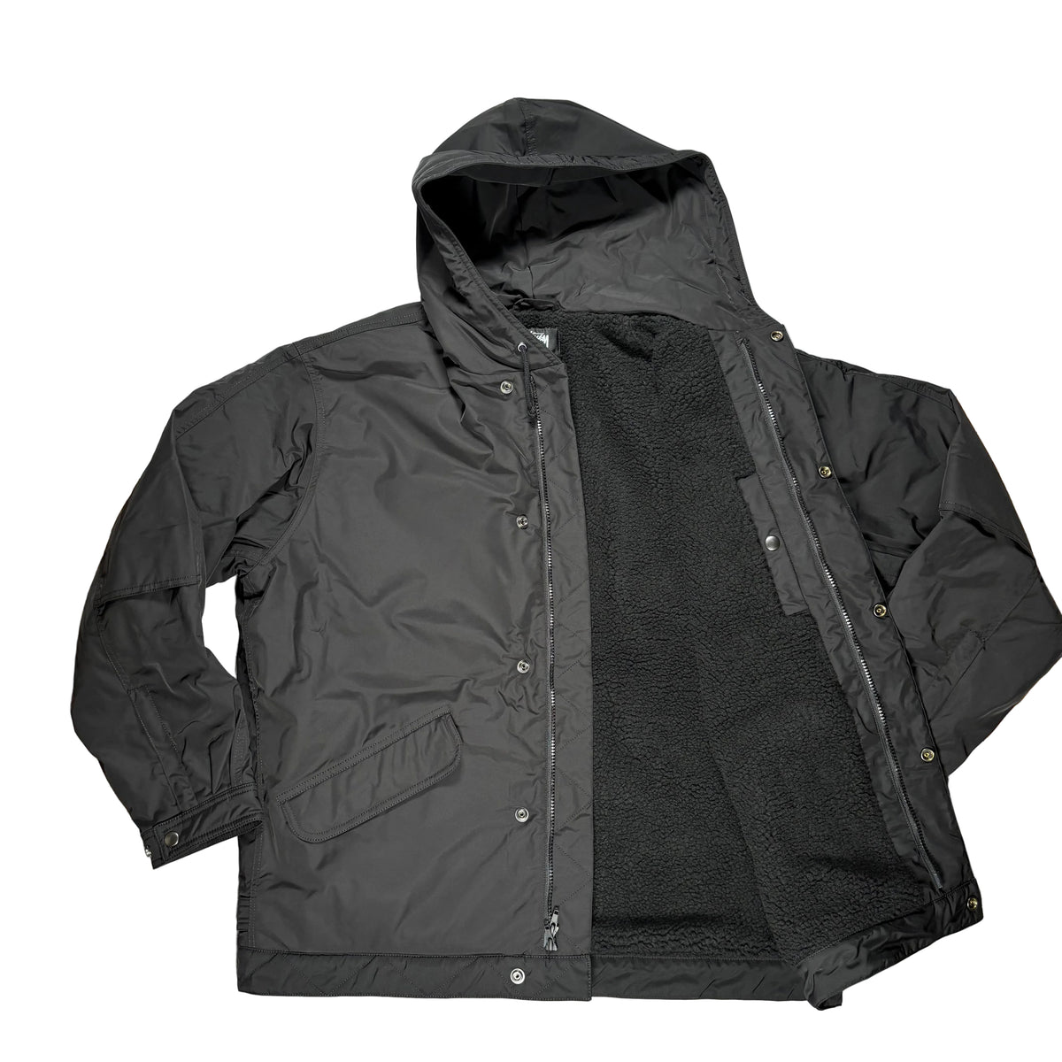 A black hooded jacket laid flat on a white surface. The jacket is open, showing a black fleece interior lining.