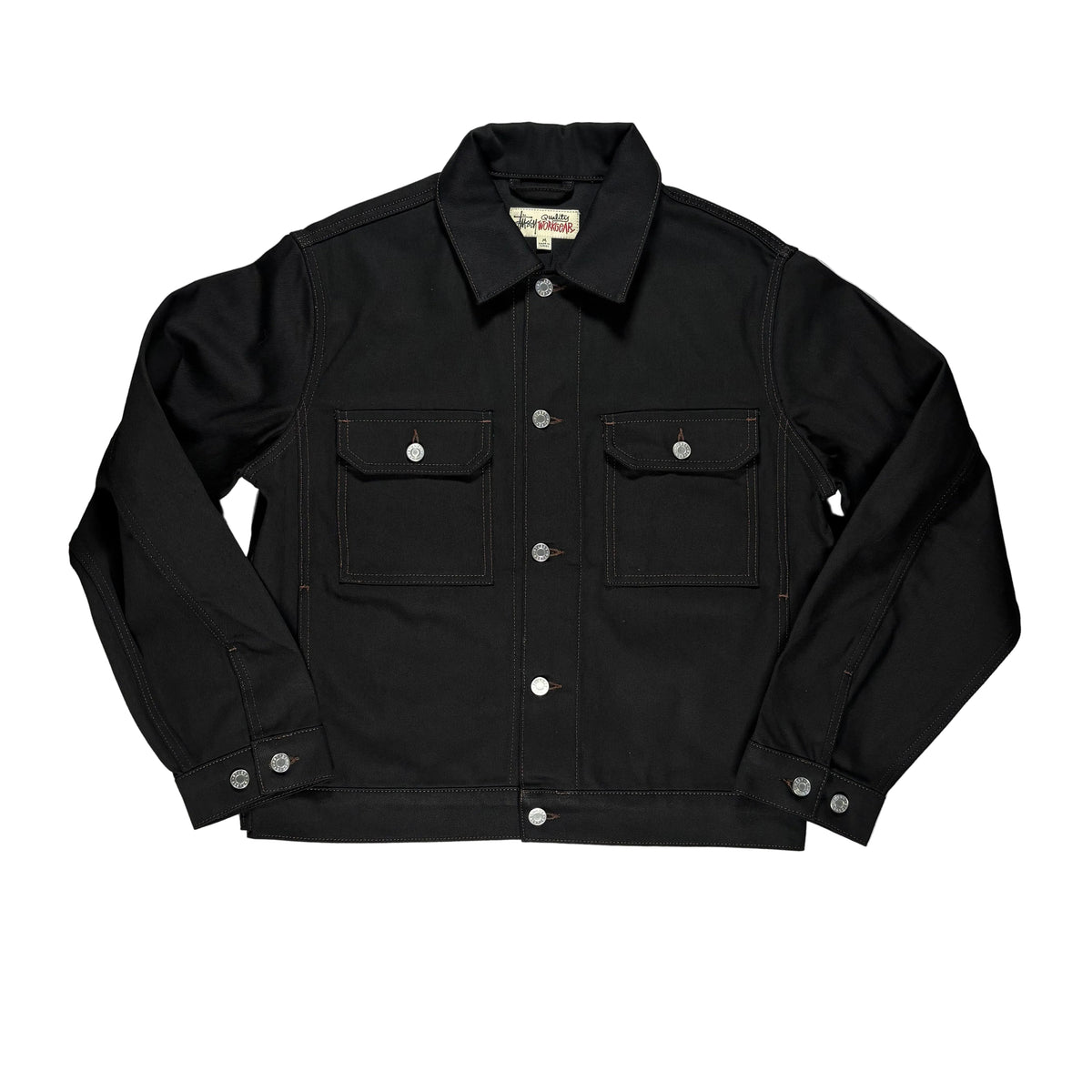 A black denim jacket laid flat on a white surface. The jacket features silver snap buttons, two large front flap pockets, and a classic collar.