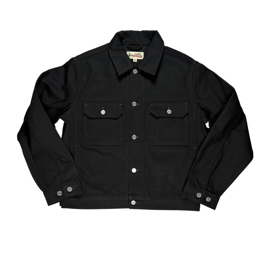 A black denim jacket laid flat on a white surface. The jacket features silver snap buttons, two large front flap pockets, and a classic collar.