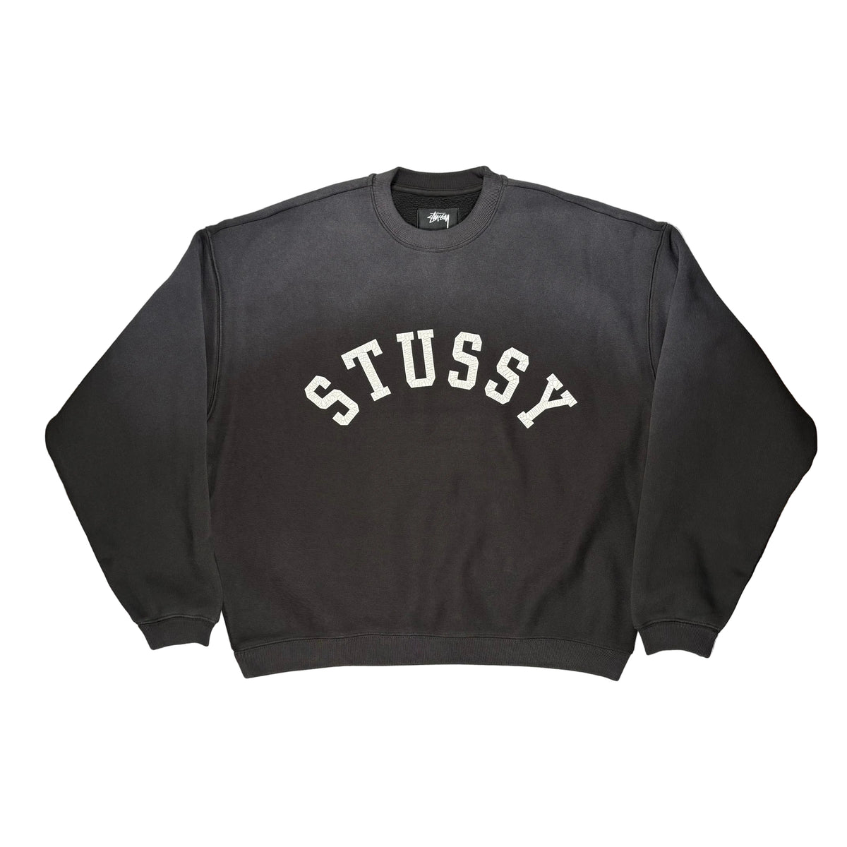 A black Stussy crewneck sweatshirt with 'STUSSY' printed in white arched block letters across the chest, laid flat on a white surface.