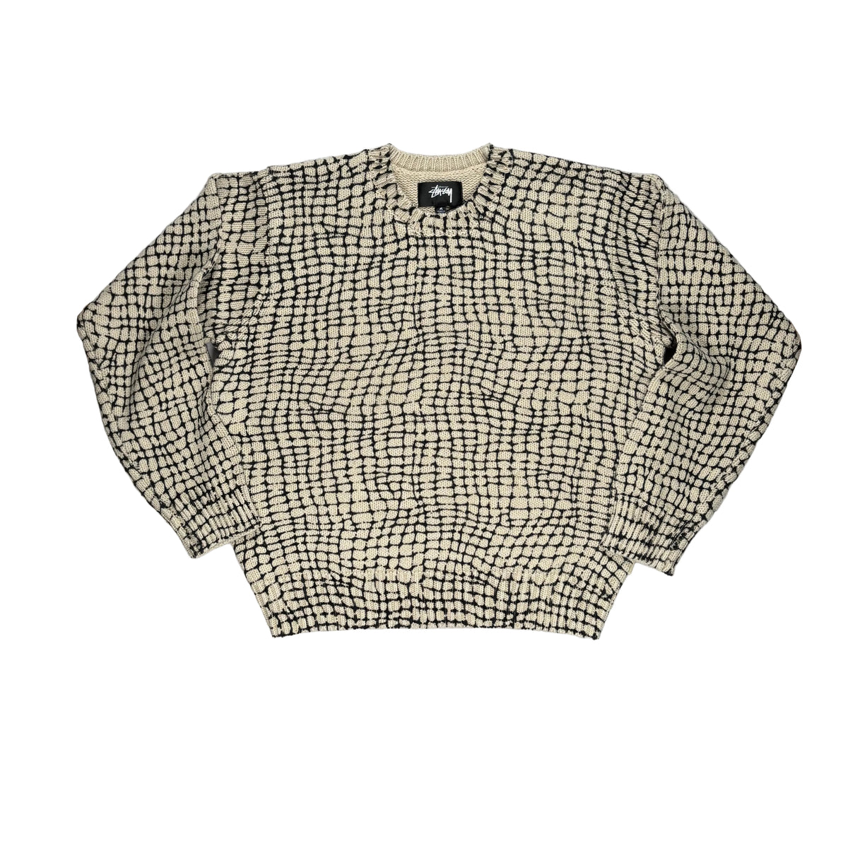 A cream and black patterned knit sweater with a grid-like woven design, laid flat on a white surface.