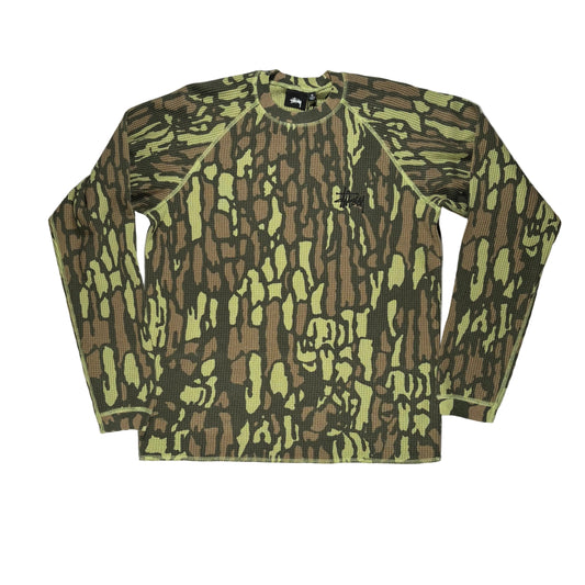 A long-sleeve crewneck shirt with an all-over camouflage pattern in olive green, brown, and black, laid flat on a white surface.