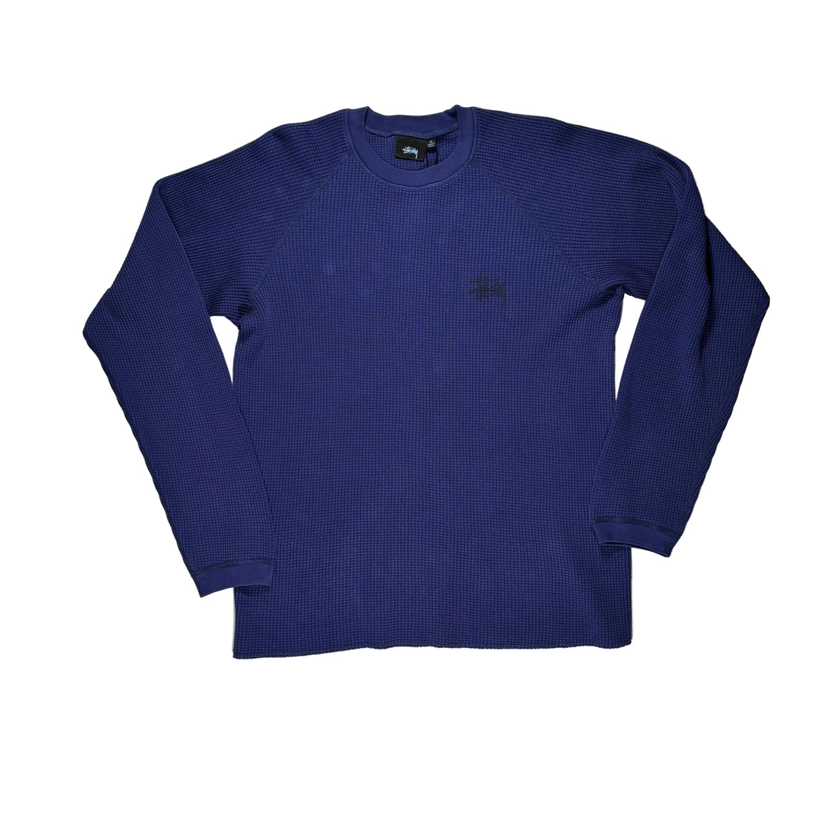 A navy blue ribbed long-sleeve crewneck shirt by Stüssy, laid flat on a white surface.
