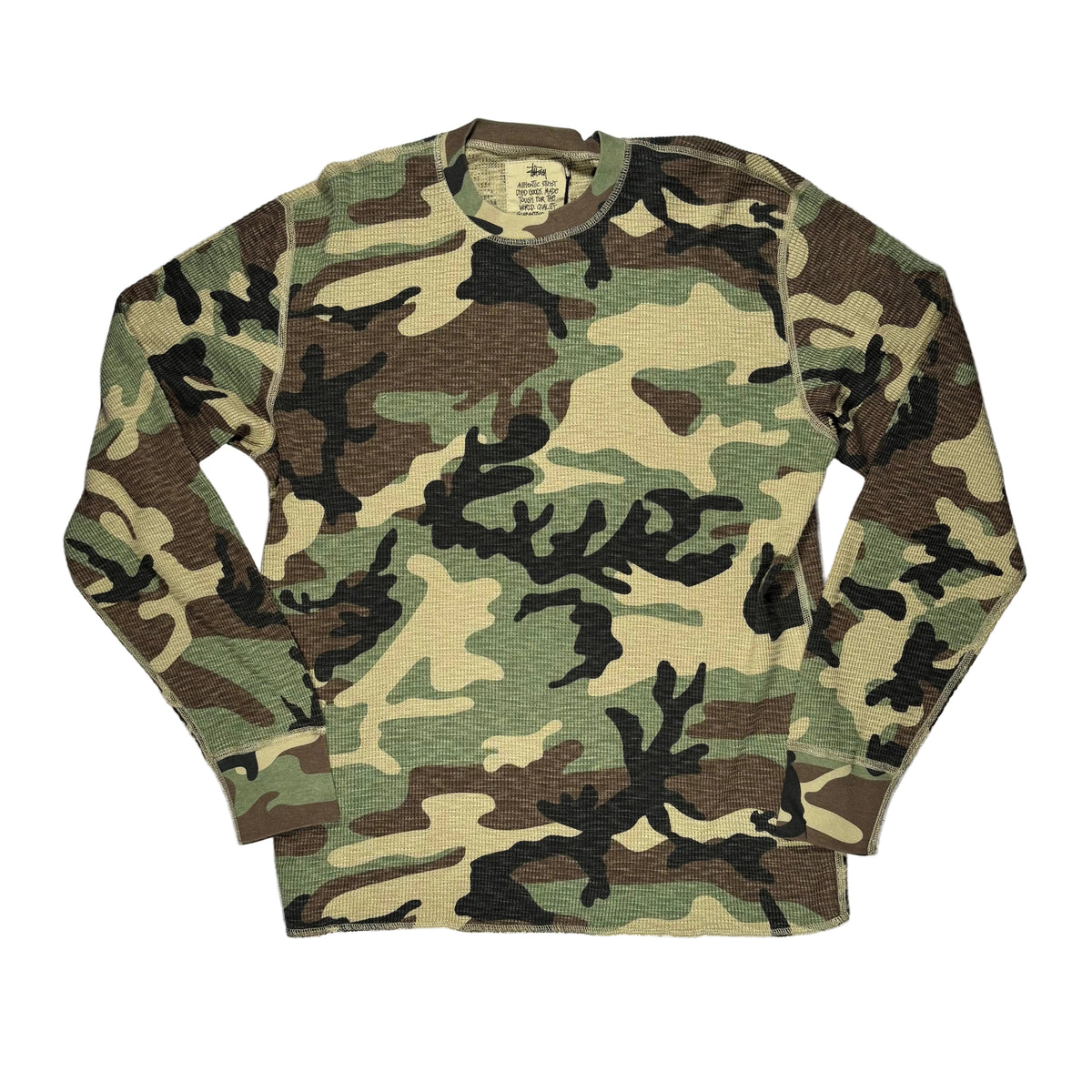 A long-sleeve waffle-knit crewneck shirt in a classic woodland camouflage pattern, laid flat on a white background.