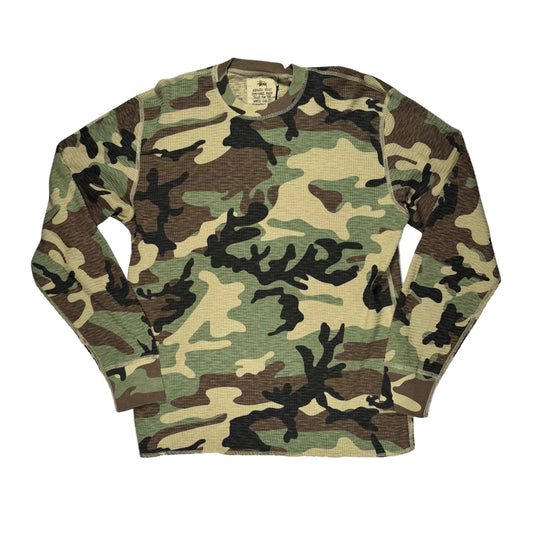A long-sleeve waffle-knit crewneck shirt in a classic woodland camouflage pattern, laid flat on a white background.
