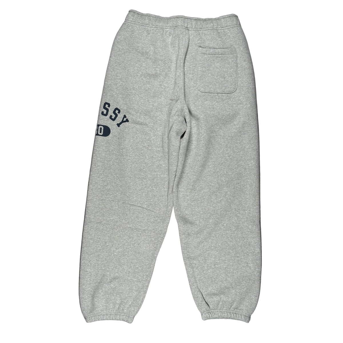 A pair of light heather gray sweatpants laid flat on a white surface, showing the back view with a back pocket and partial navy blue 'STUSSY' lettering.