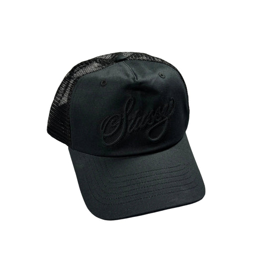 A black trucker cap with a black mesh back and an embroidered black script logo on the front, resting on a white background