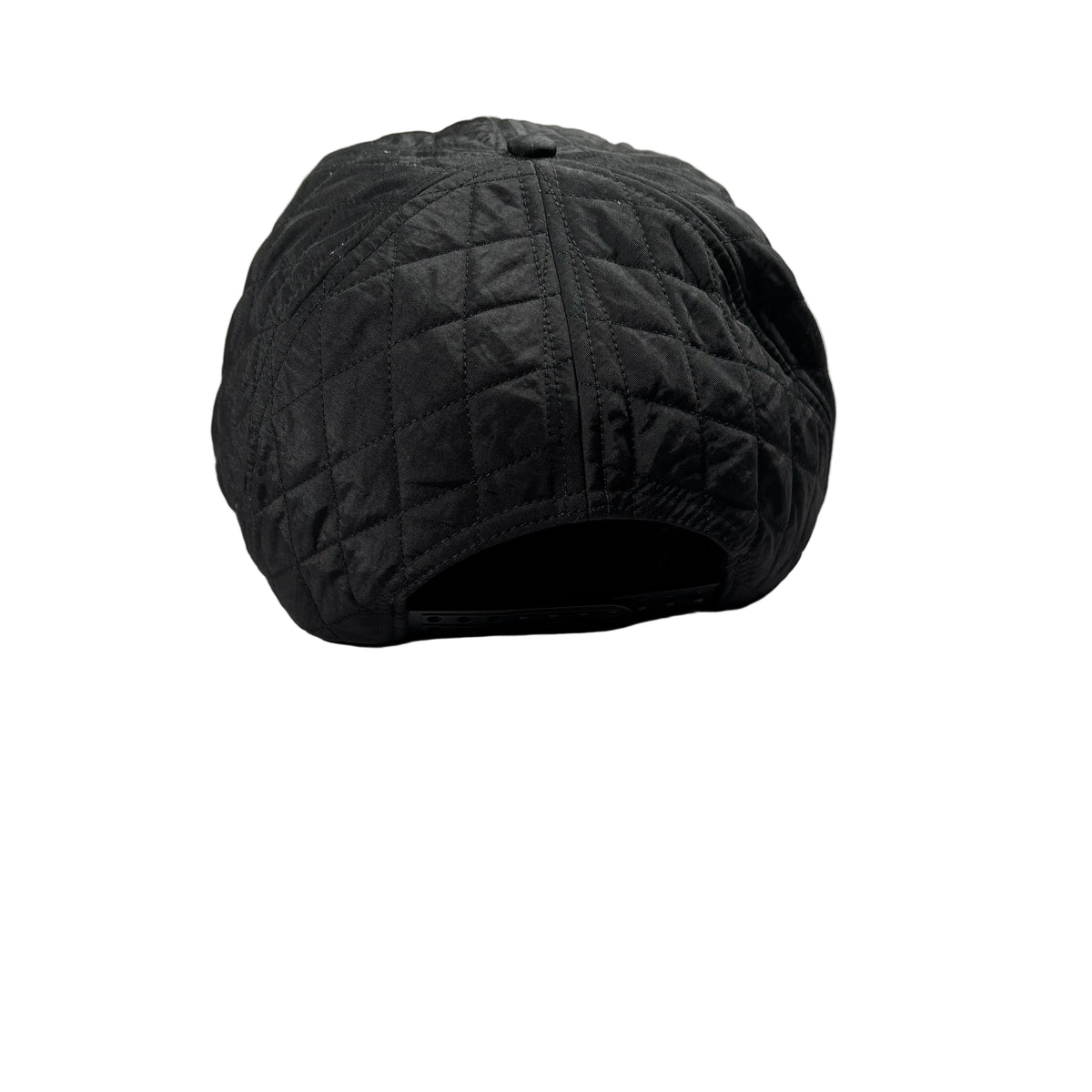 A black quilted baseball cap shown from the back, resting on a white surface.