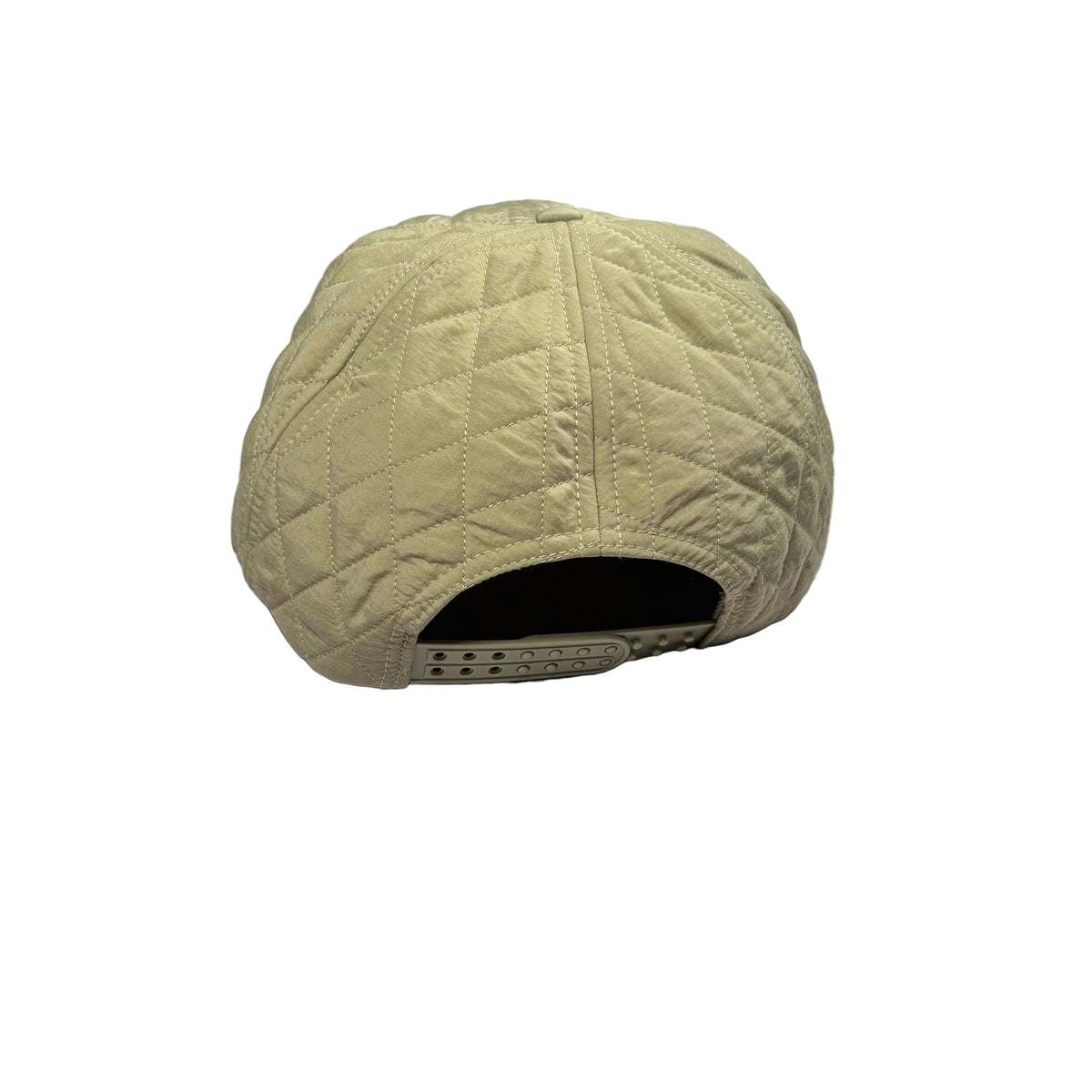 A light khaki quilted baseball cap viewed from the back, resting on a white surface.