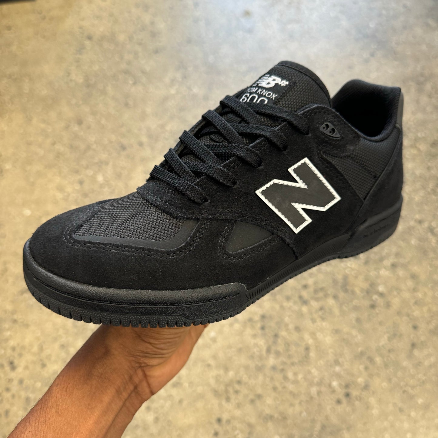 all black suede/mesh shoe with white accent around the logo