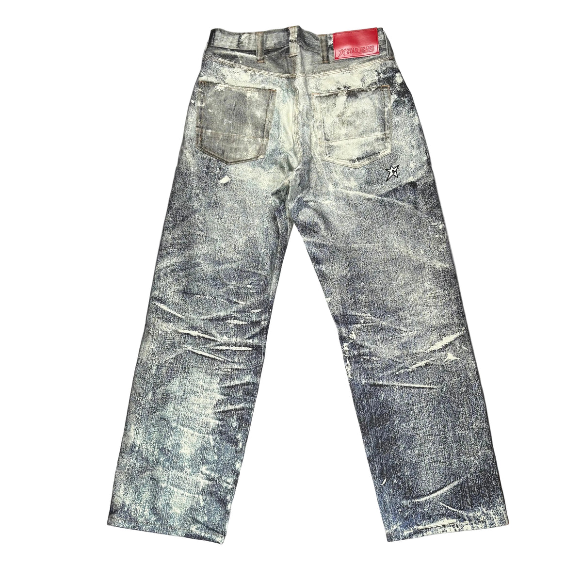 A pair of heavily distressed and faded gray jeans laid flat on a sheet of white surface.