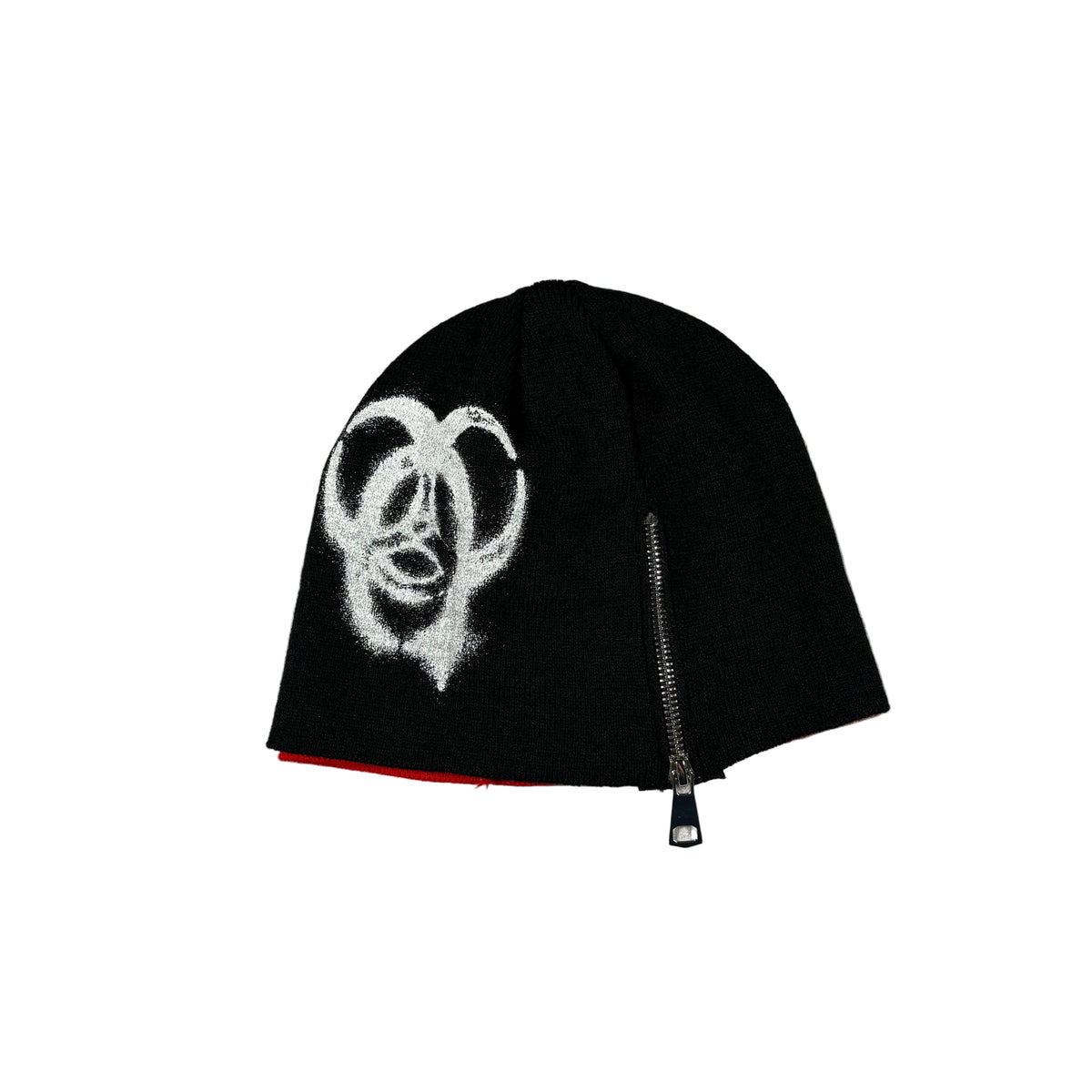 A black knit beanie hat featuring a white spray-painted graphic, a silver zipper on the side, and a red inner lining peeking out at the bottom, displayed on a white background.