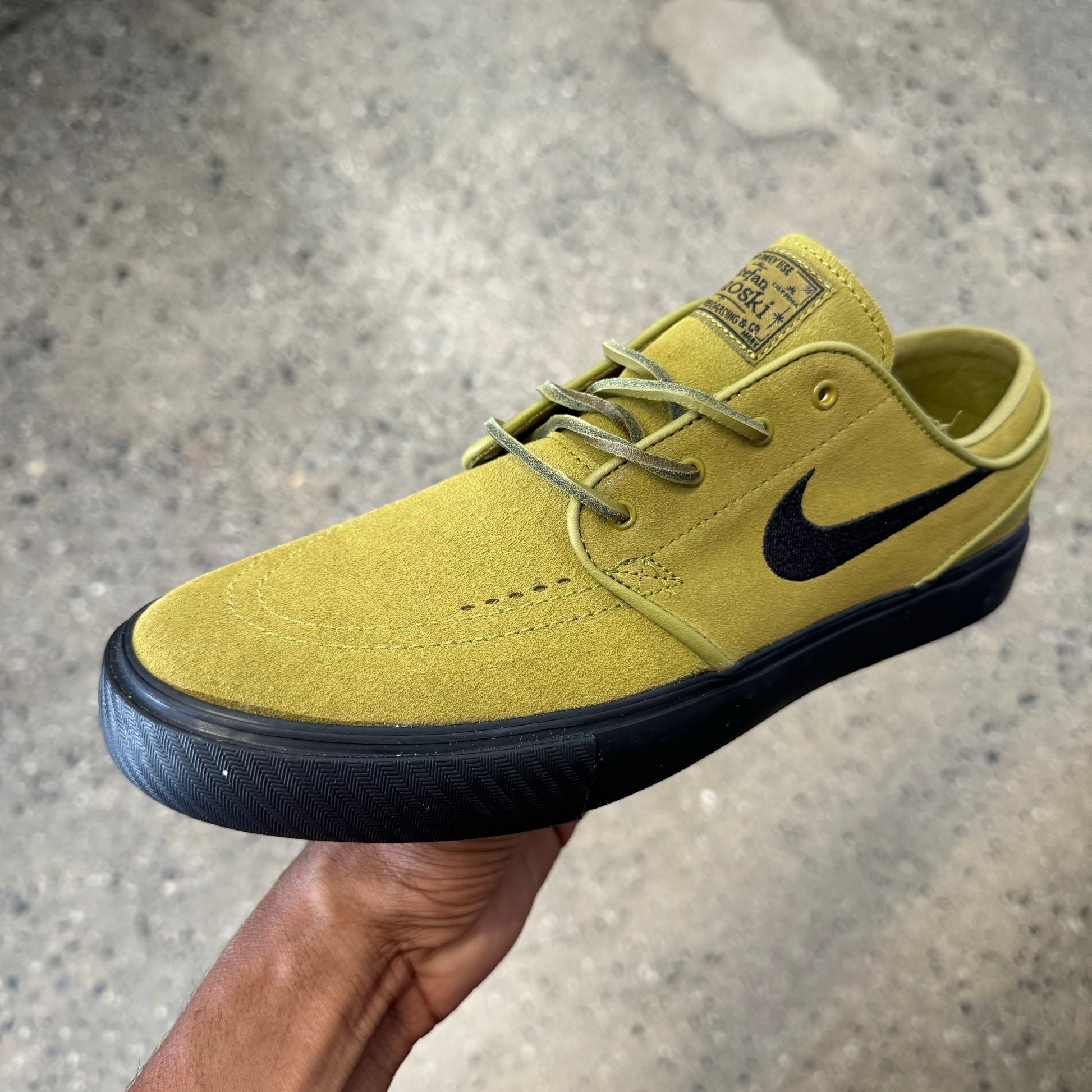 moss green colored suede shoe with black sole and logo