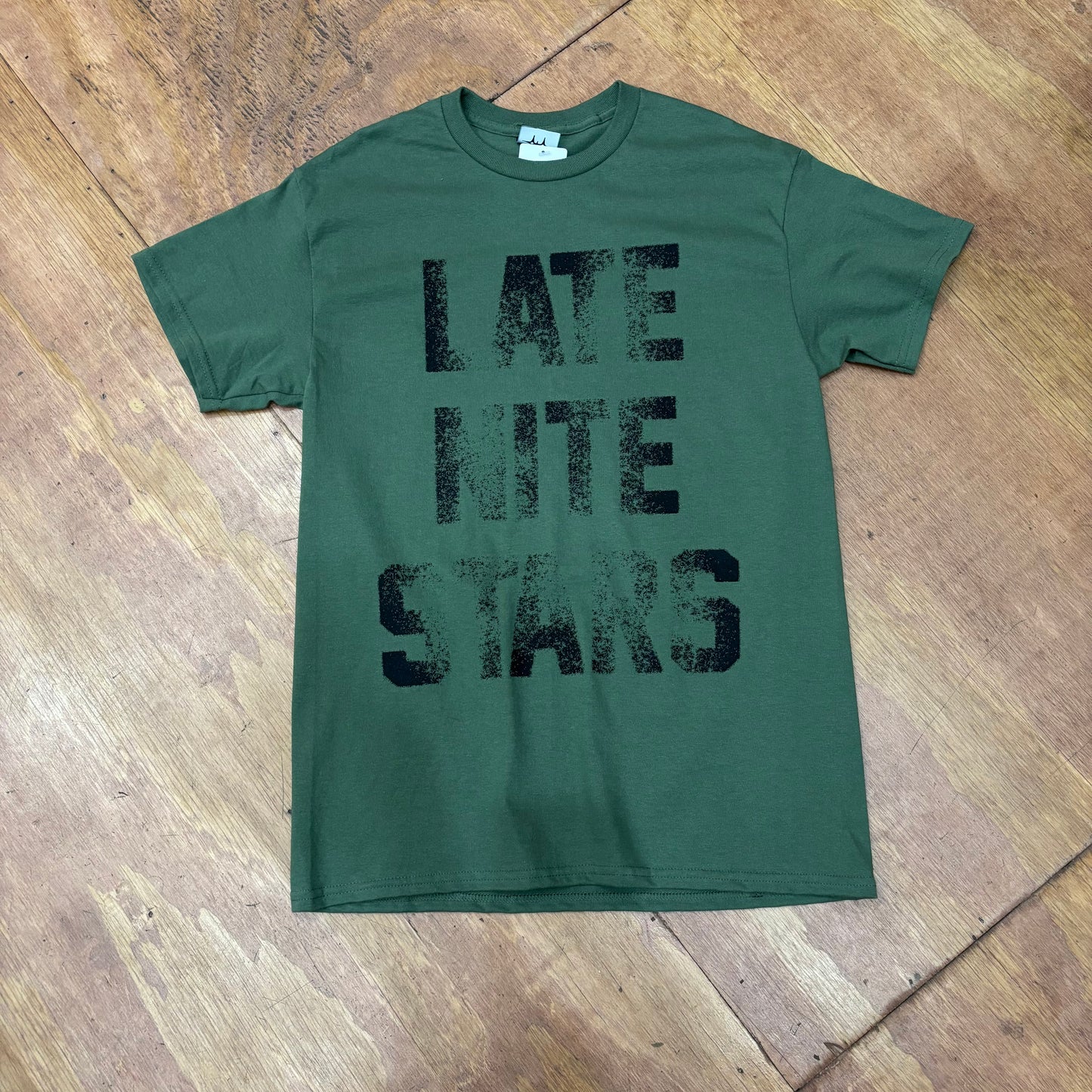 front view of olive green t-shirt with LATE NITE STARS logo on center of t-shirt, with slight old school letterpress style look
