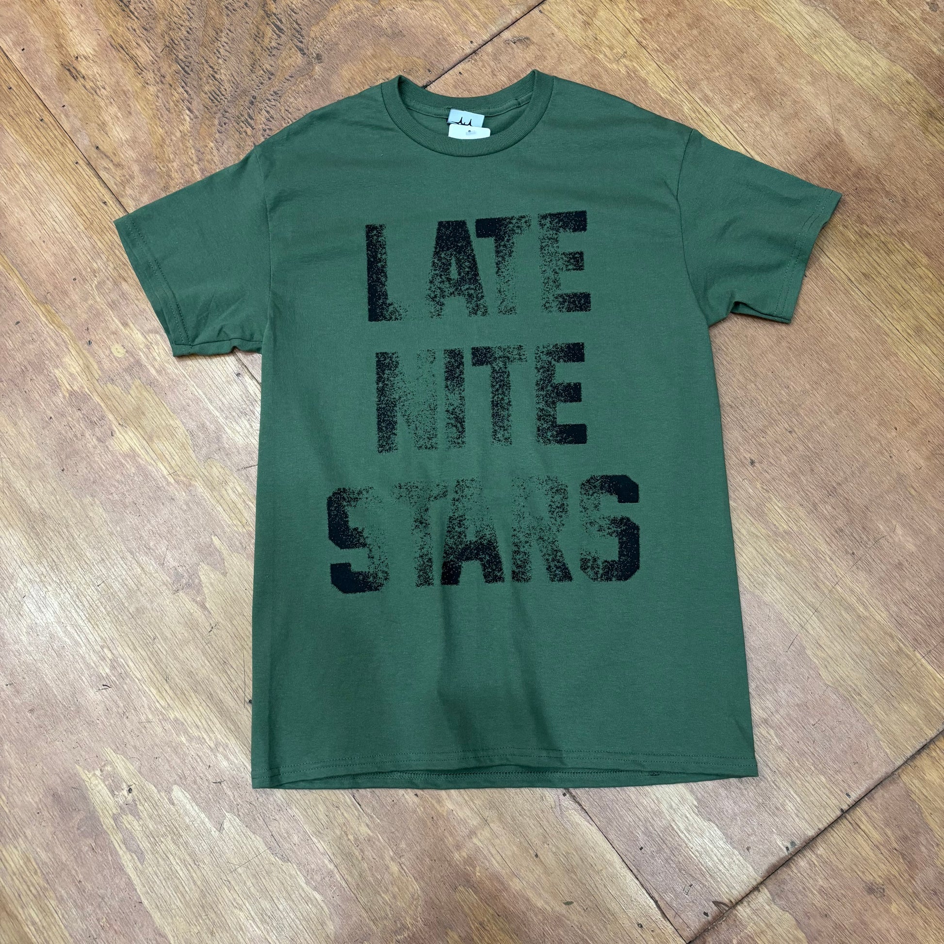 front view of olive green t-shirt with LATE NITE STARS logo on center of t-shirt, with slight old school letterpress style look