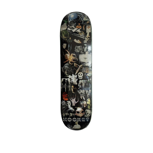 A skateboard deck with a black background and a dense collage of horror-themed graphics, skulls, spiders, and occult imagery, displayed vertically on a white sheet.