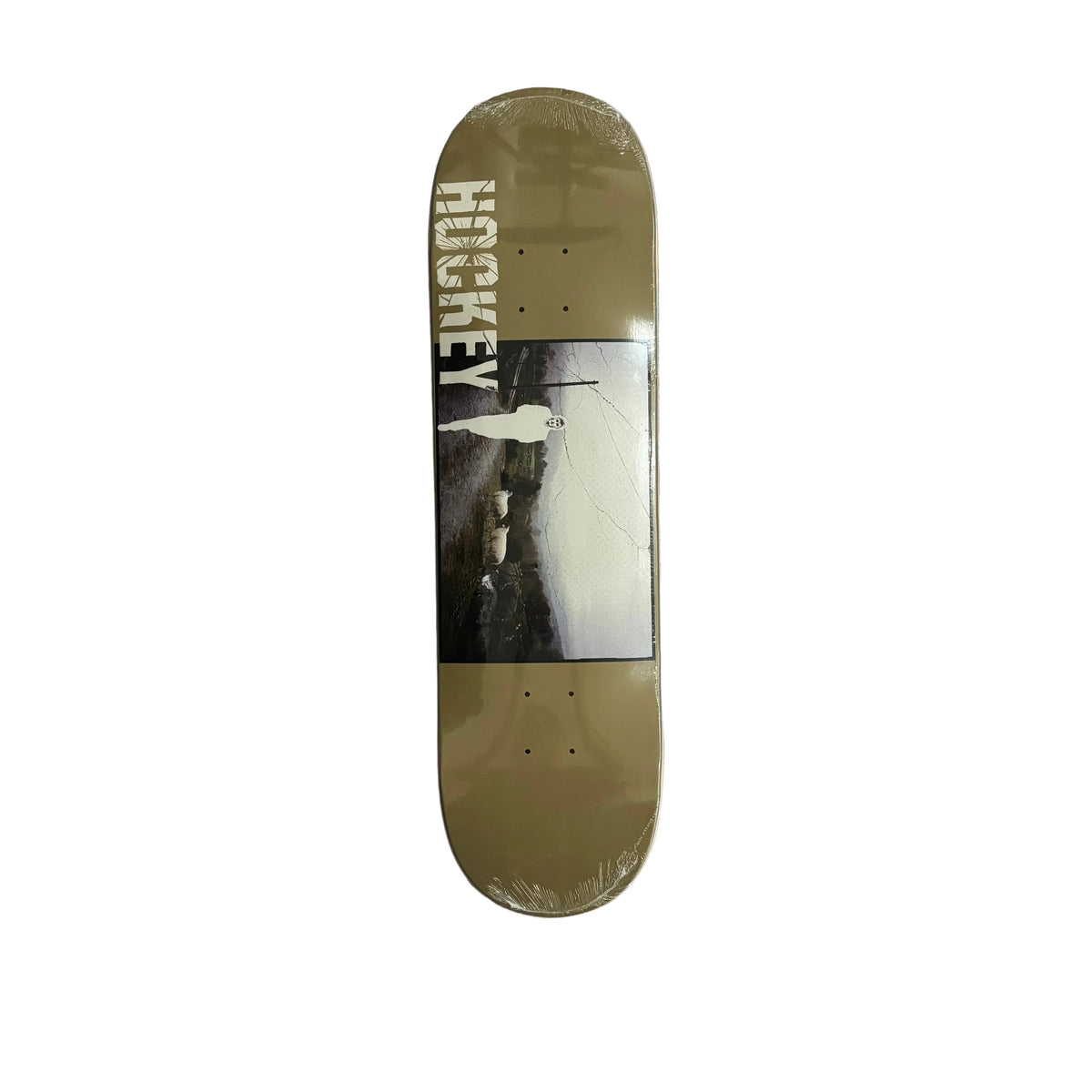 A hockey deck skateboard in a protective plastic sleeve, featuring a muted olive green deck with a central graphic of a person and the word 'HOCKEY' printed vertically in white. Displayed on a white surface.