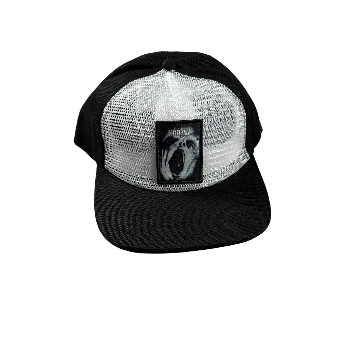 A black and white trucker hat with a black mesh back and a black visor, featuring a square black patch on the front with a white-and-black screaming face and the word 'Hockey'.