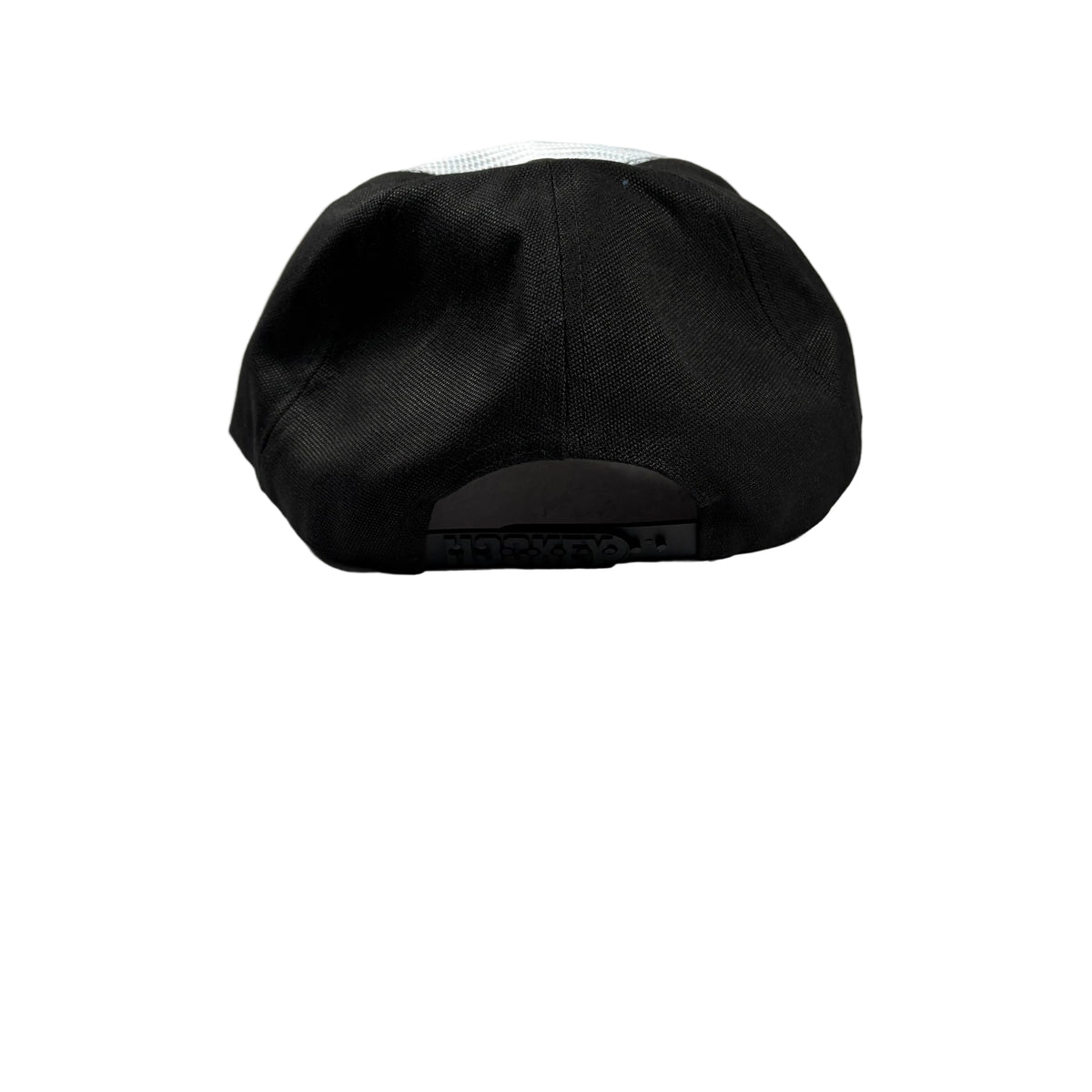 A black snapback trucker cap viewed from the back, resting on a white surface.