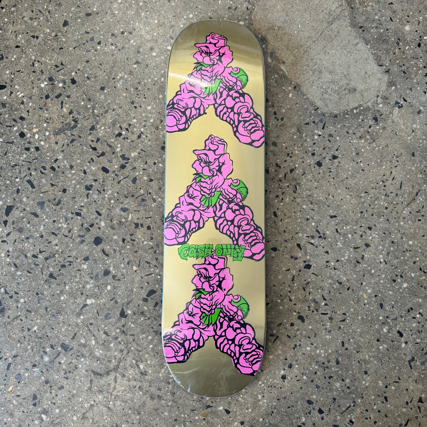 gold skateboard deck with hot pink character holding a fist full of money