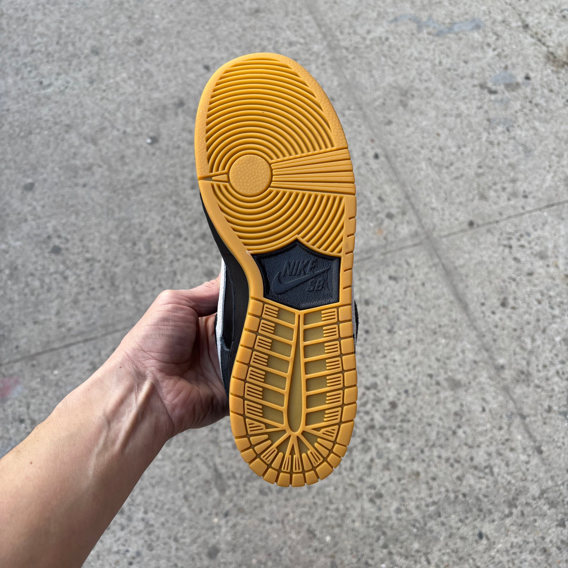 view of gum rubber outsole on black/white nike sb dunk low