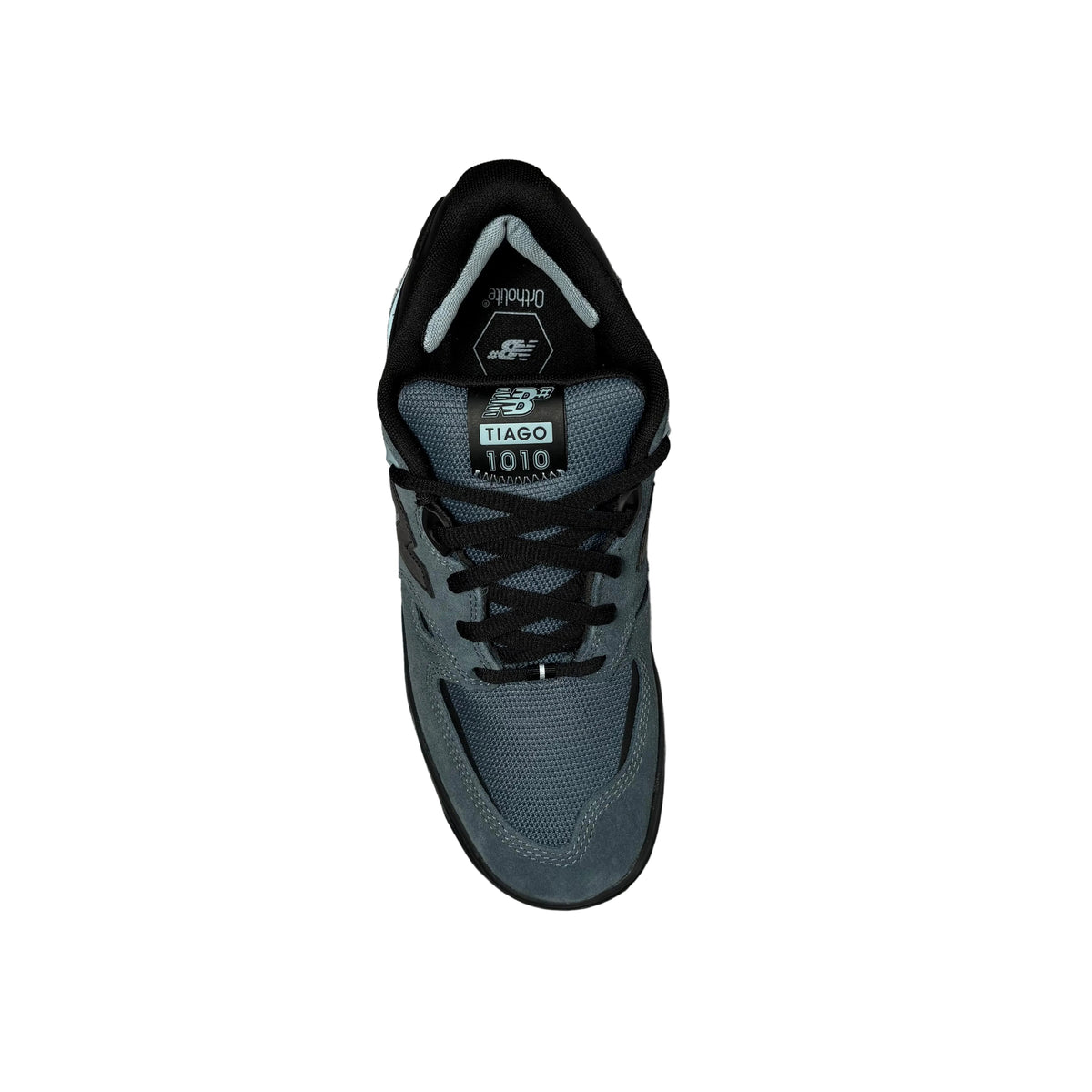 A single New Balance 1010 Tiago shoe in dark gray and black, photographed from a top-down perspective on a white surface.