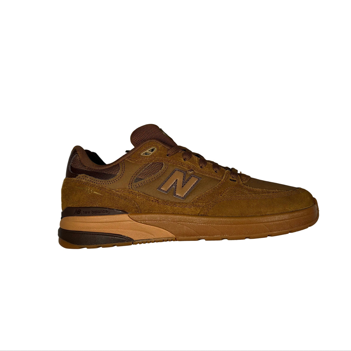 A single New Balance sneaker in brown suede and mesh, positioned horizontally on a white surface.