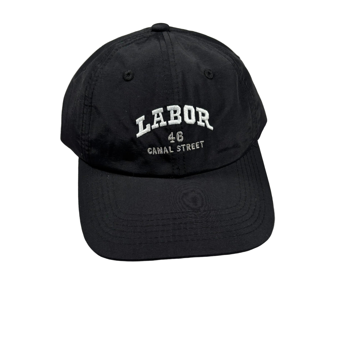 A black baseball cap with white embroidered text reading 'LABOR 48 CANAL STREET' on the front, photographed on a light white surface.