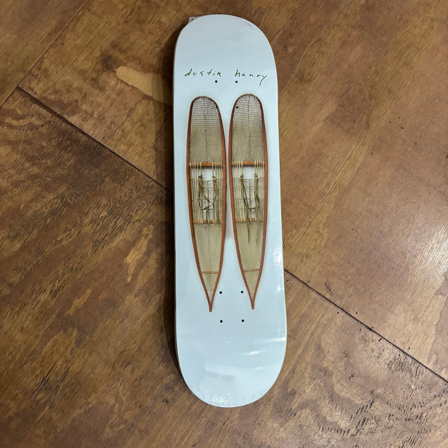 White skateboard deck with two elongated snow shoes