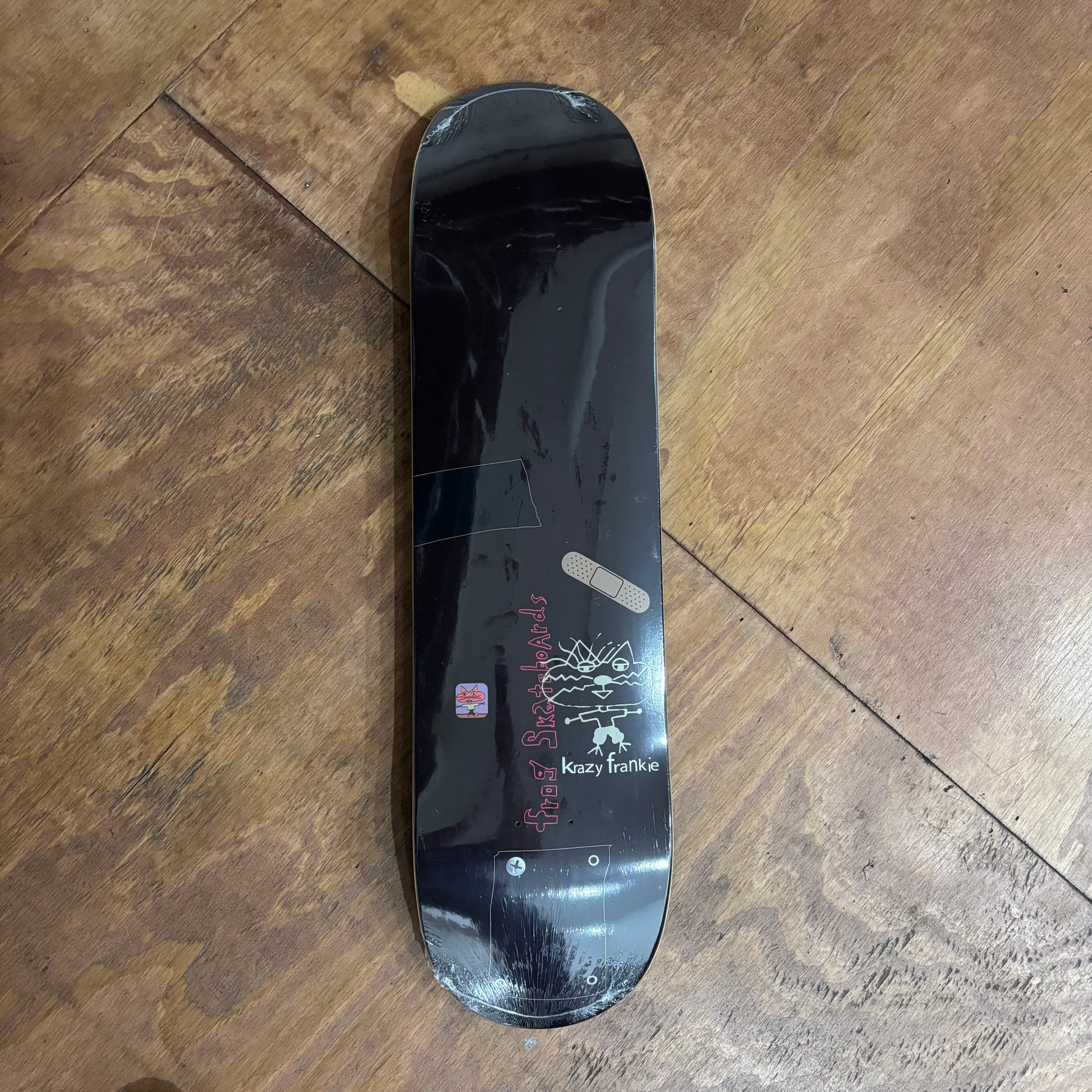 black skateboard deck with hand drawn kitty on the bottom