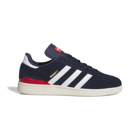 Side view of navy, white suede lowtop soccer style shoe with red accent on heel