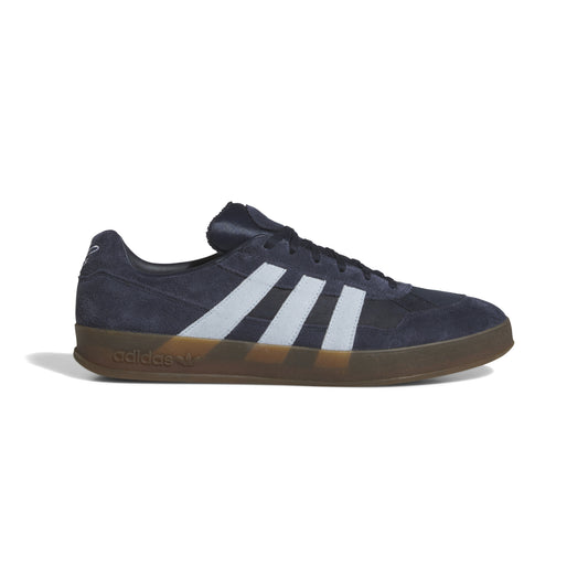 side view of navy lowtop sneaker with gum rubber outsole and grey three stripes