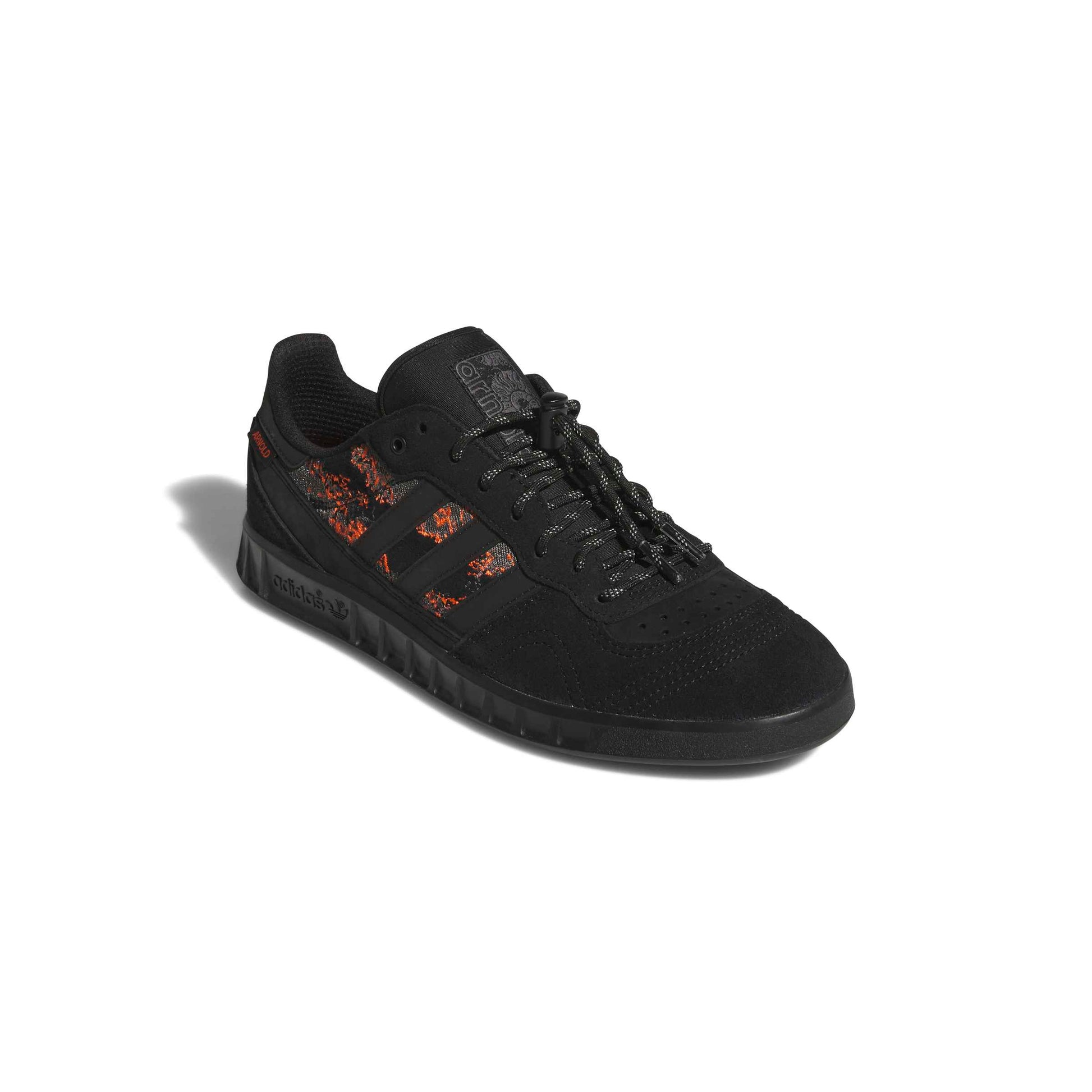 Black sneaker with orange accents on a white background
