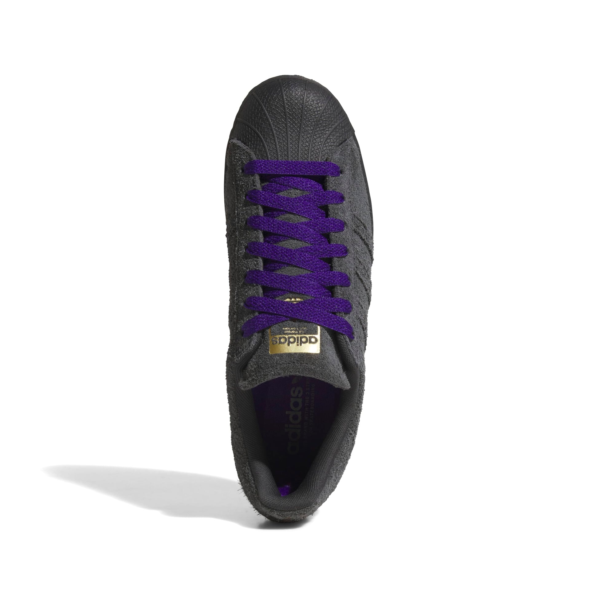 Black Adidas sneaker with purple laces on a white background