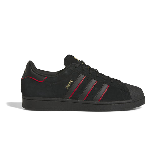 side view of black nubuck superstar sneaker with red accented stripes 