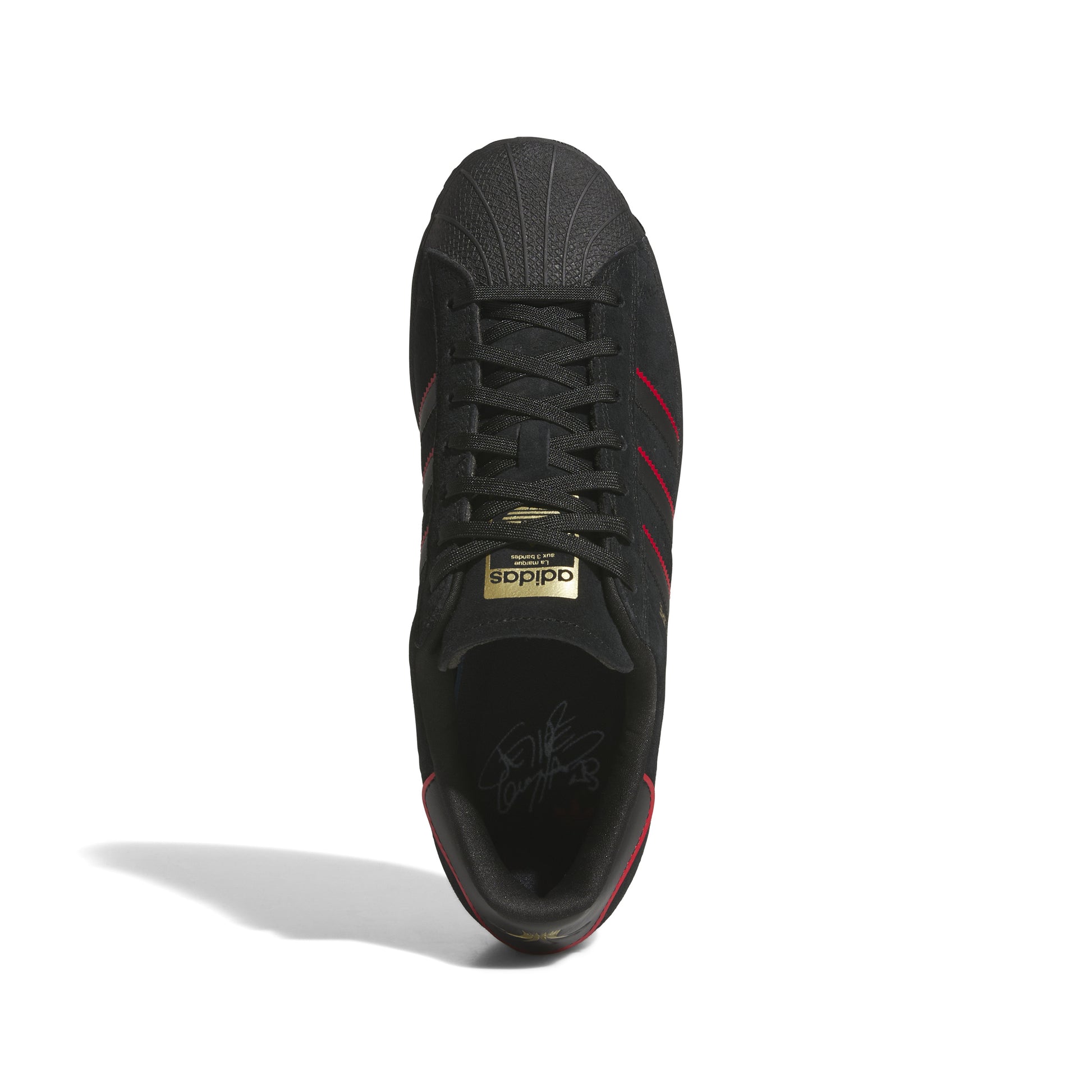 top down view of black nubuck superstar sneaker with red accented stripes 