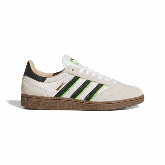 White sneaker with black and green stripes on a white background
