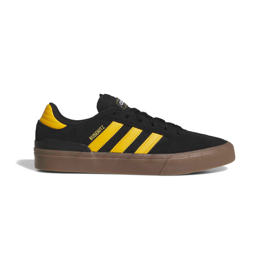 Black and yellow sneaker with brown gum sole on a white background