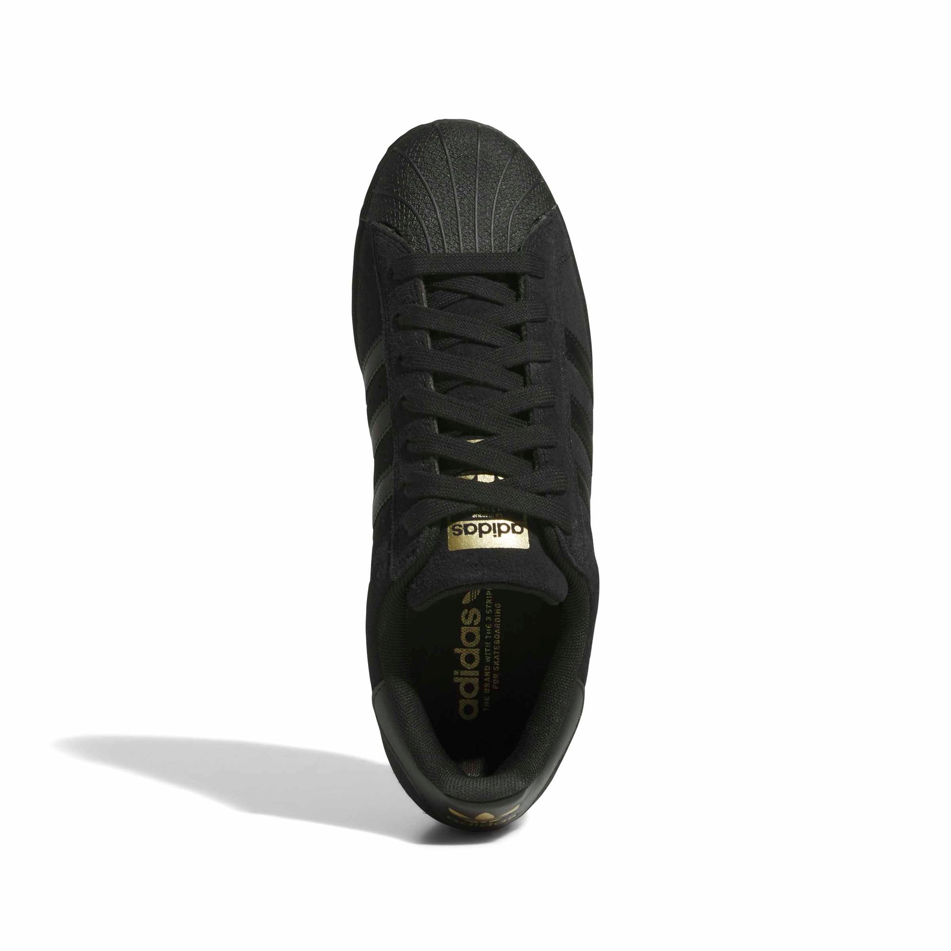A single black Adidas Superstar sneaker shown from a top-down view on a white background, featuring a metallic gold logo on the tongue and gold branding on the inner sole.