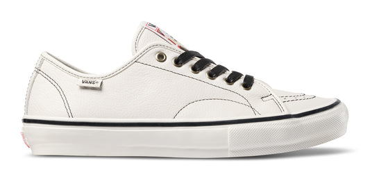 A low-top Vans sneaker in off-white leather with black laces, a black stripe along the midsole, and a thick white sole.
