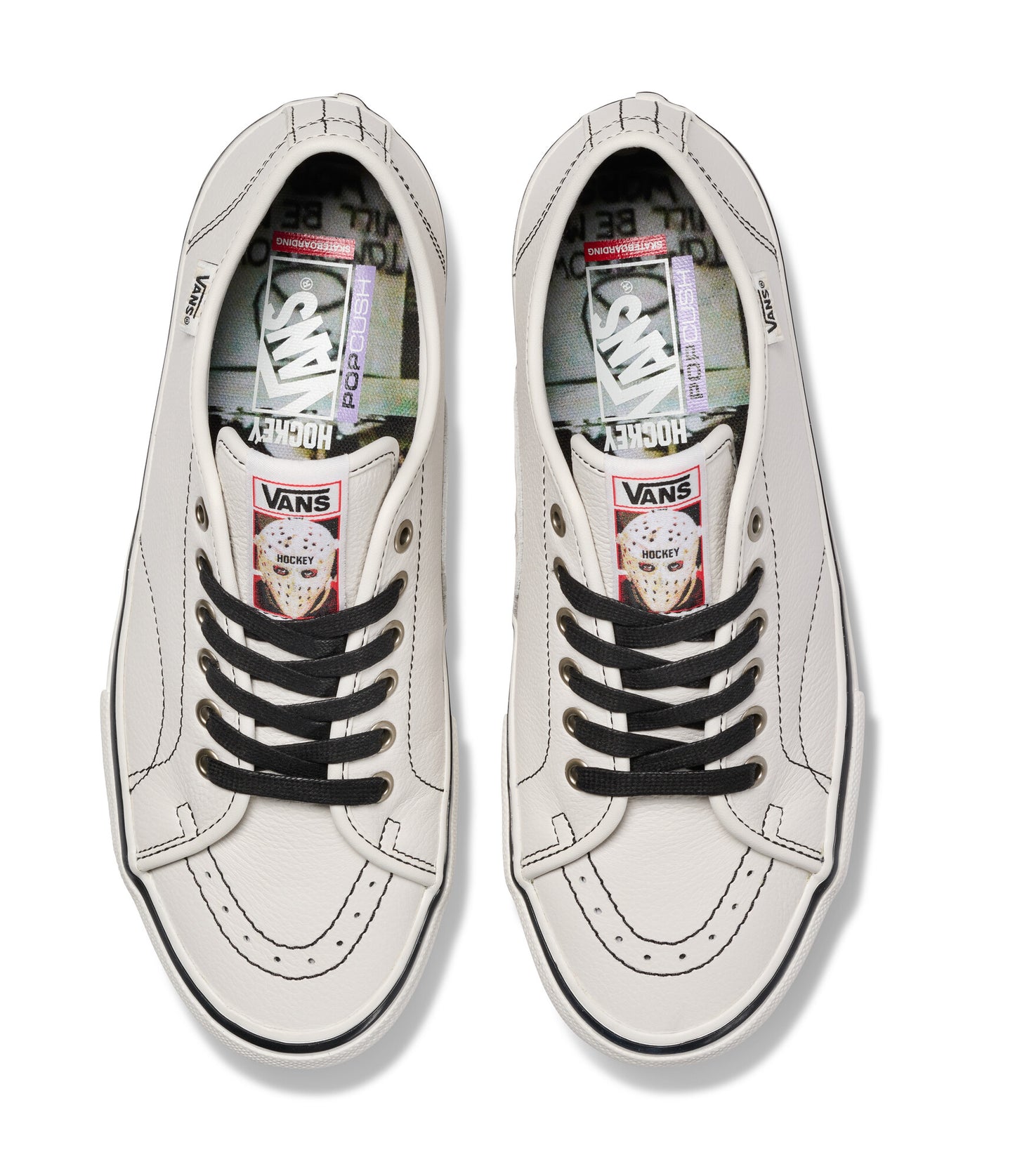 Pair of white Vans sneakers with black laces on a white background