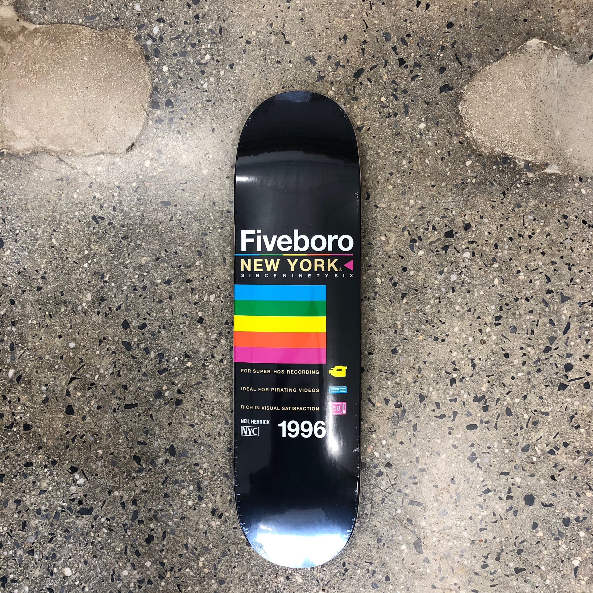 black skateboard with rainbow color graphic and text