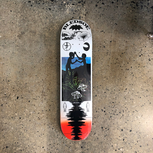 white skateboard deck with black abstract illustrations with a photo of kids playing on the beach in the center