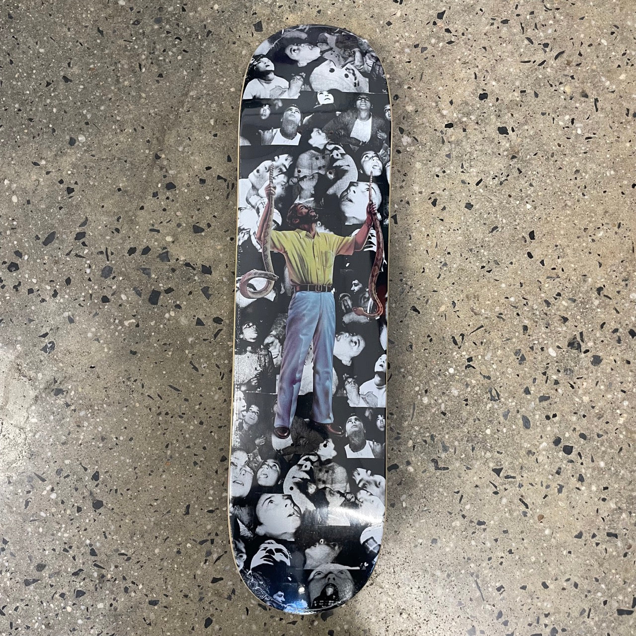 skateboard deck with a collage of faces and a man holding two snakes